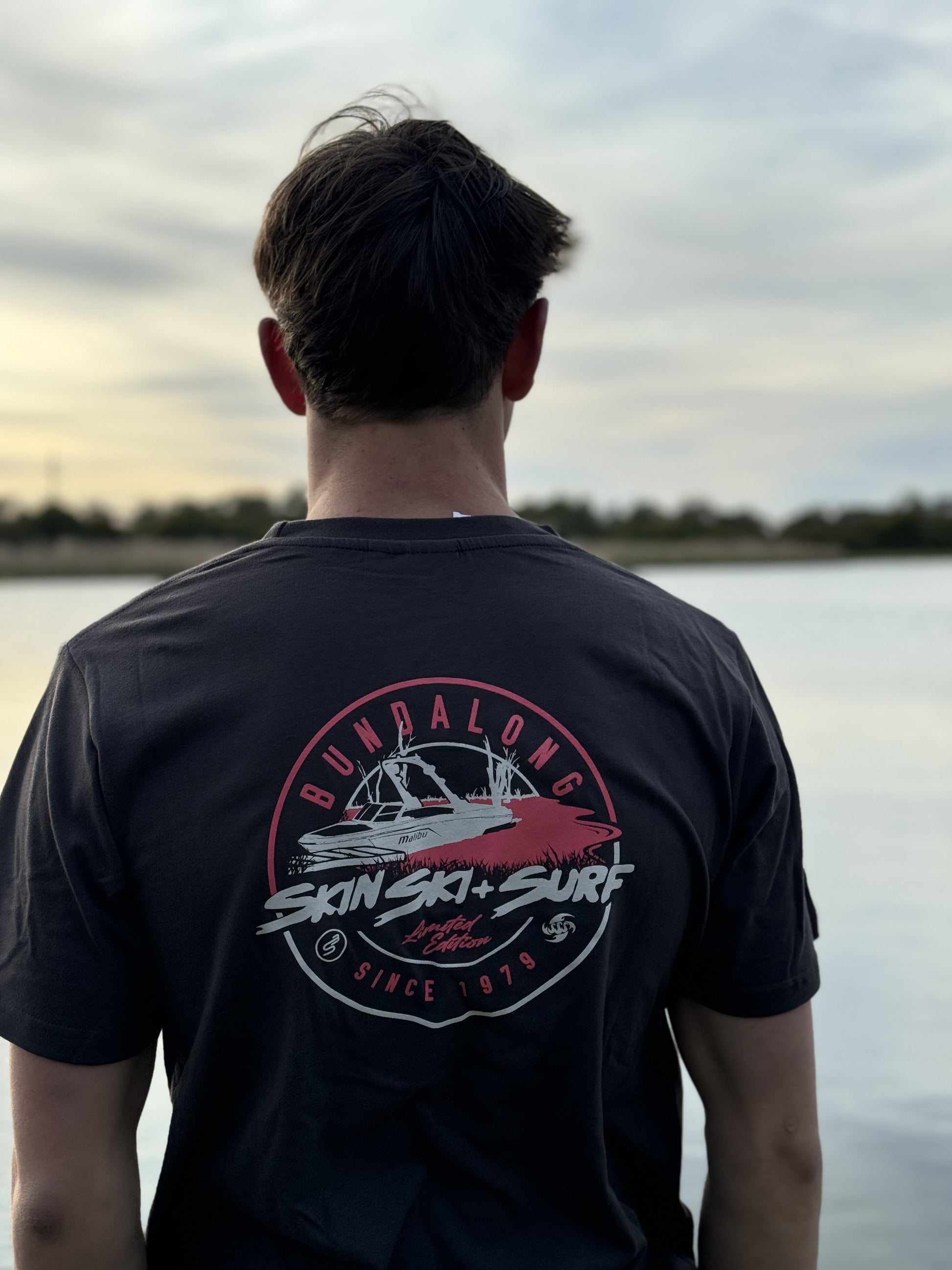 a man looking at the water wearing a Bunda lip t shirt from Skin Ski + Surf